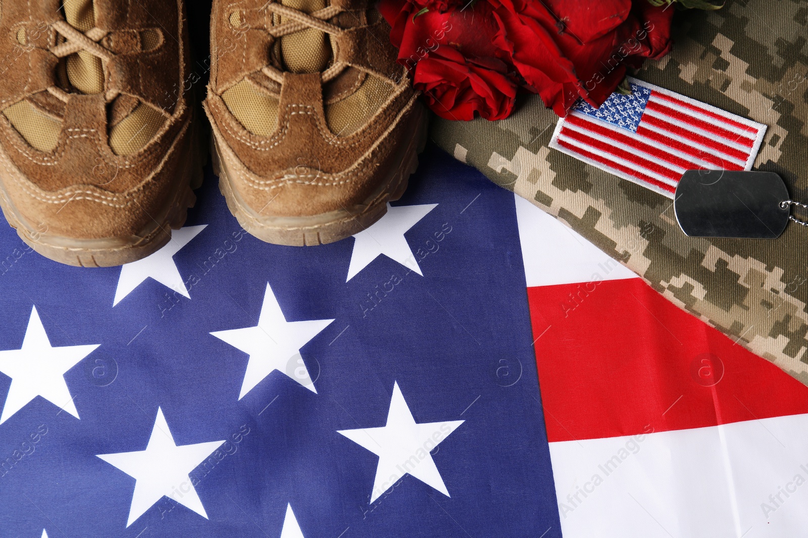 Photo of Veterans day. USA army patch, token, American flag, roses and military shoes, flat lay