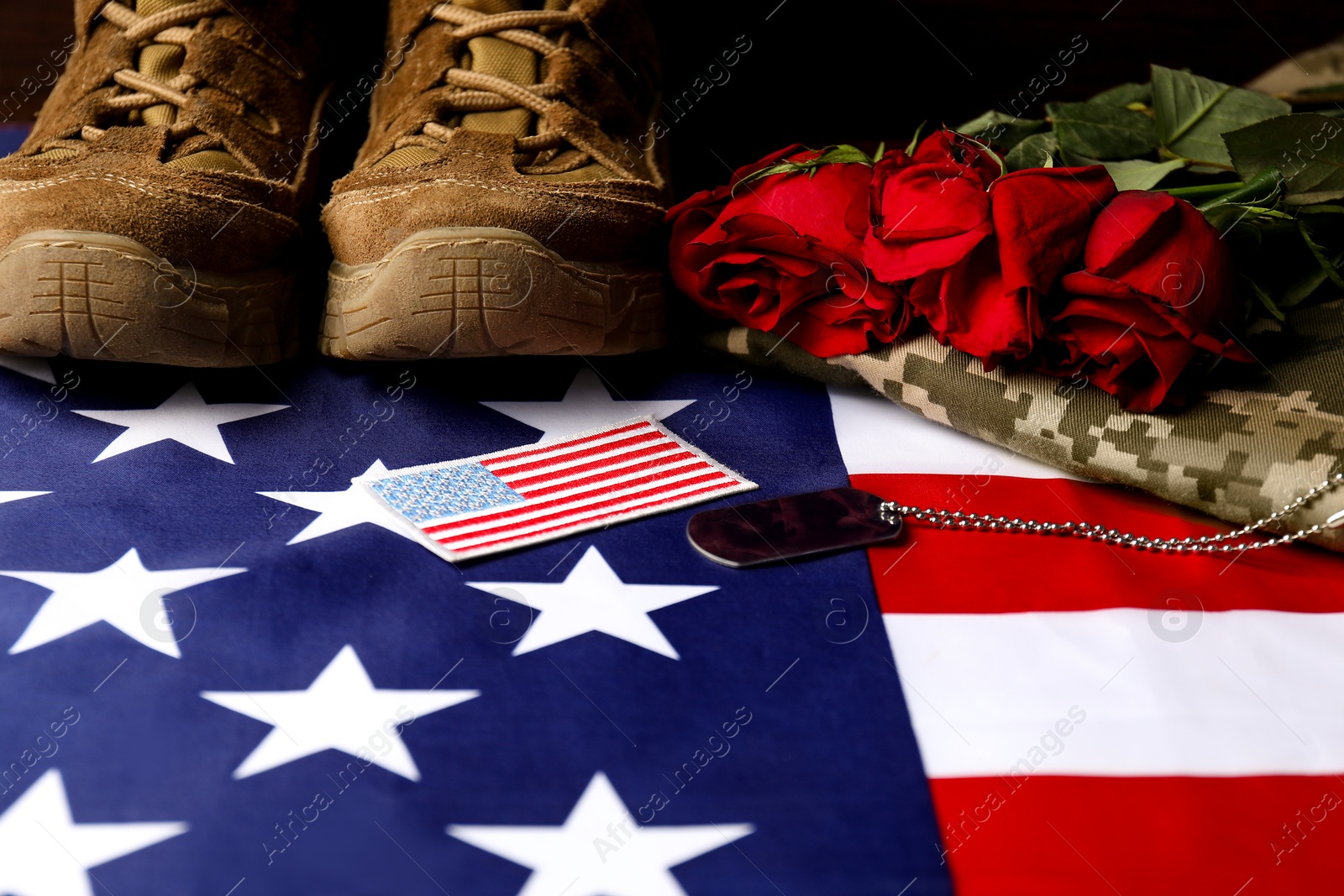 Photo of Veterans day. USA army patch, token, American flag, roses and military shoes, closeup