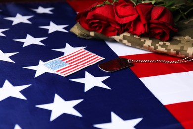 Photo of Veterans day. USA army patch, token, American flag, roses and military uniform, closeup