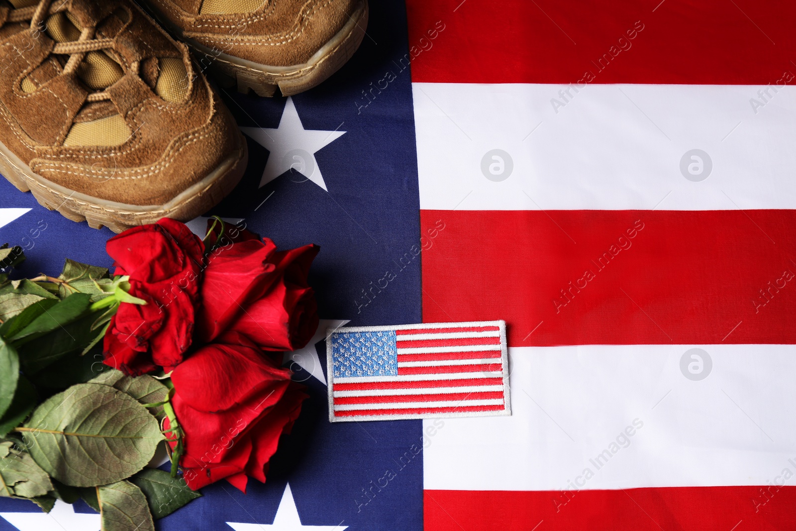 Photo of Veterans day. USA army patch, American flag, roses and military shoes, flat lay