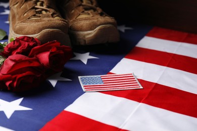 Photo of Veterans day. USA army patch, American flag, roses and military shoes, closeup