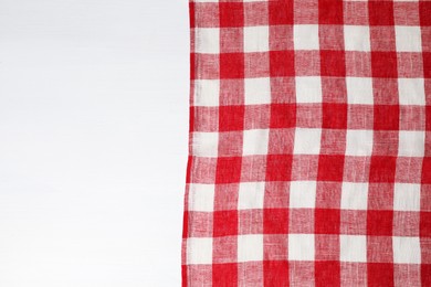 Photo of Tablecloth with checkered pattern on white wooden table, top view. Space for text