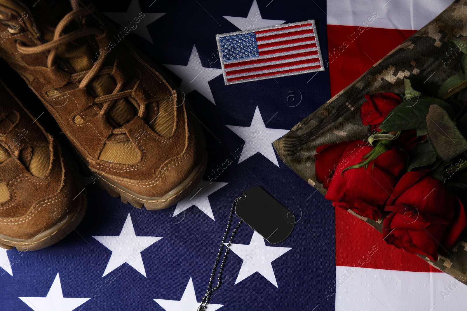 Photo of Veterans day. USA army patch, token, American flag, roses and military uniform, flat lay