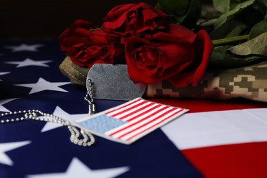 Photo of Veterans day. USA army patch, American flag, roses, token and military uniform, closeup