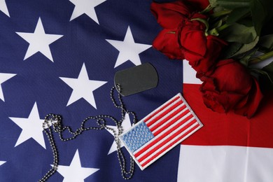 Photo of Veterans day. USA army patch, American flag, roses and token, flat lay