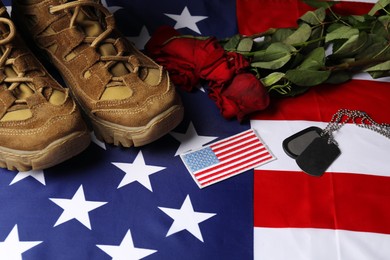 Photo of Veterans day. USA army patch, American flag, roses, tokens and military shoes, closeup