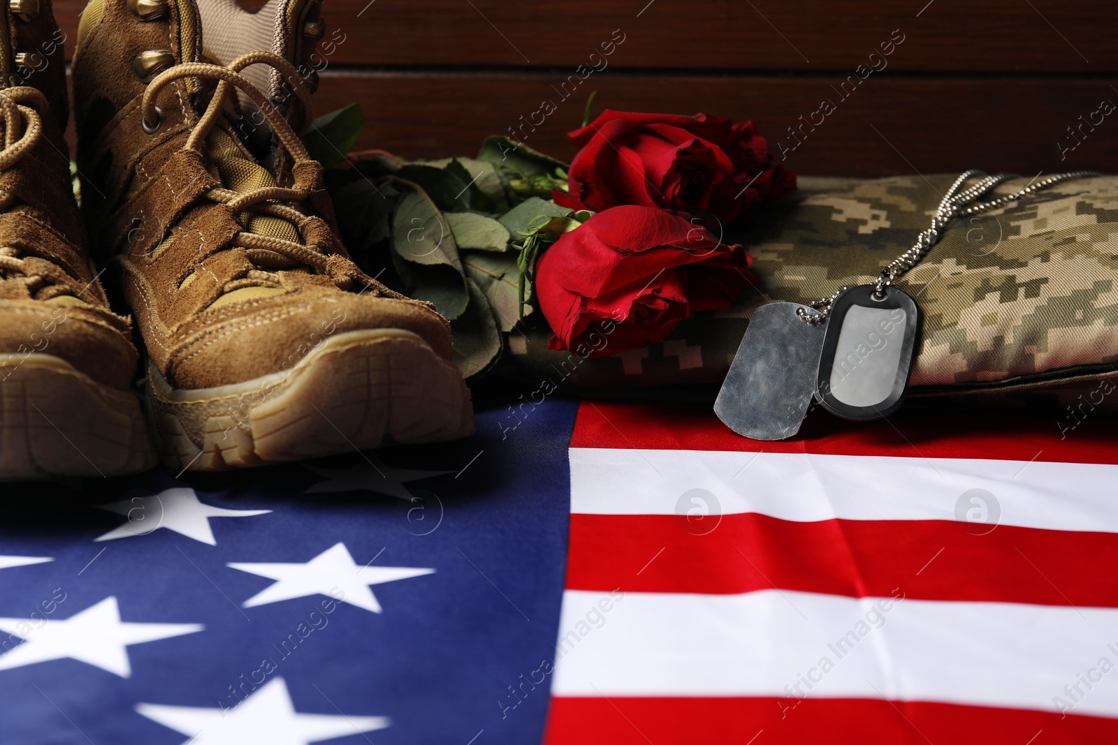 Photo of Veterans day. Army tokens, American flag, roses and military shoes, closeup