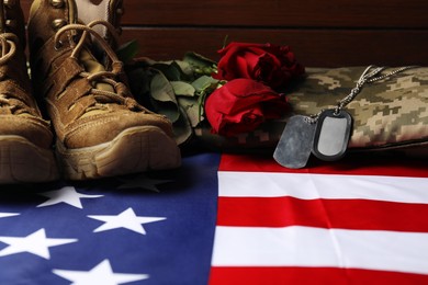 Photo of Veterans day. Army tokens, American flag, roses and military shoes, closeup