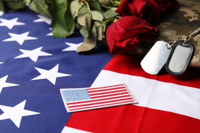 Photo of Veterans day. USA army patch, tokens, American flag, roses and military uniform, closeup