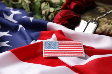 Photo of Veterans day. USA army patch, tokens, American flag, roses and military uniform, closeup