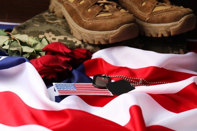 Photo of Veterans day. USA army patch, tokens, American flag, roses and military uniform, closeup