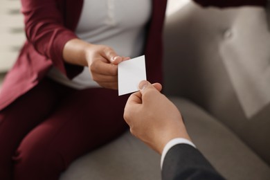 Photo of Woman giving business card to man in office, closeup. Mockup for design