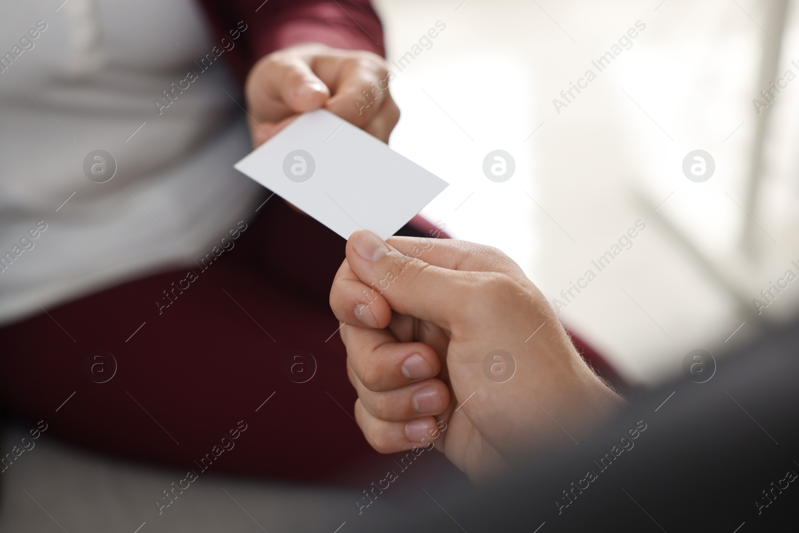 Photo of Woman giving business card to man in office, closeup. Mockup for design