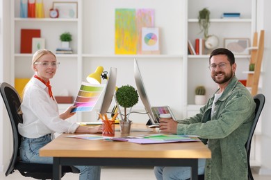 Designers working together at table in office