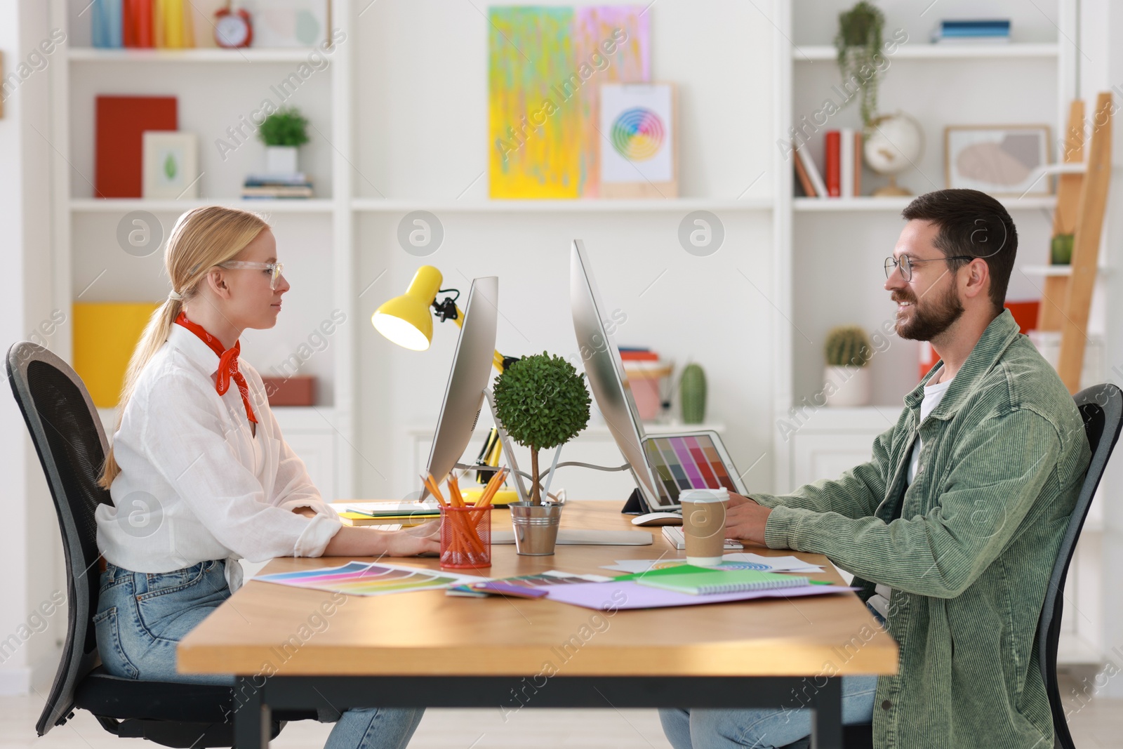 Photo of Designers working at table together in office