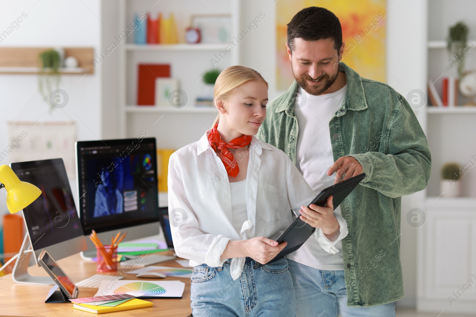 Photo of Professional designers working with tablet together in office