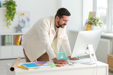 Designer working with computer at table in office