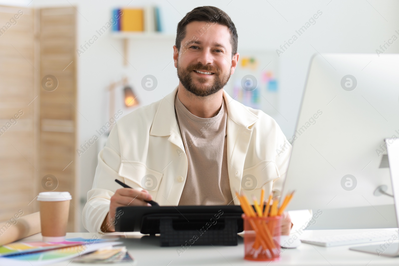 Photo of Designer working with tablet at table in office