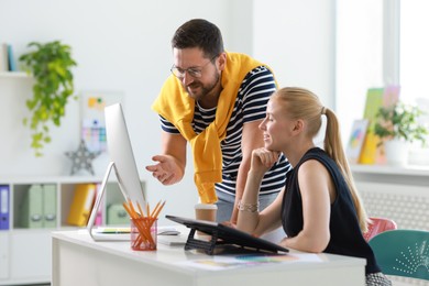 Smiling designers discussing project together in office