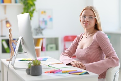 Designer working with computer at table in office