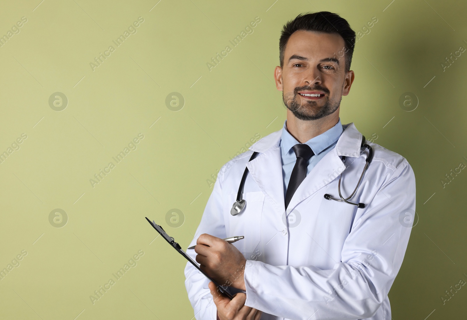 Photo of Smiling doctor with stethoscope and clipboard on olive background, space for text