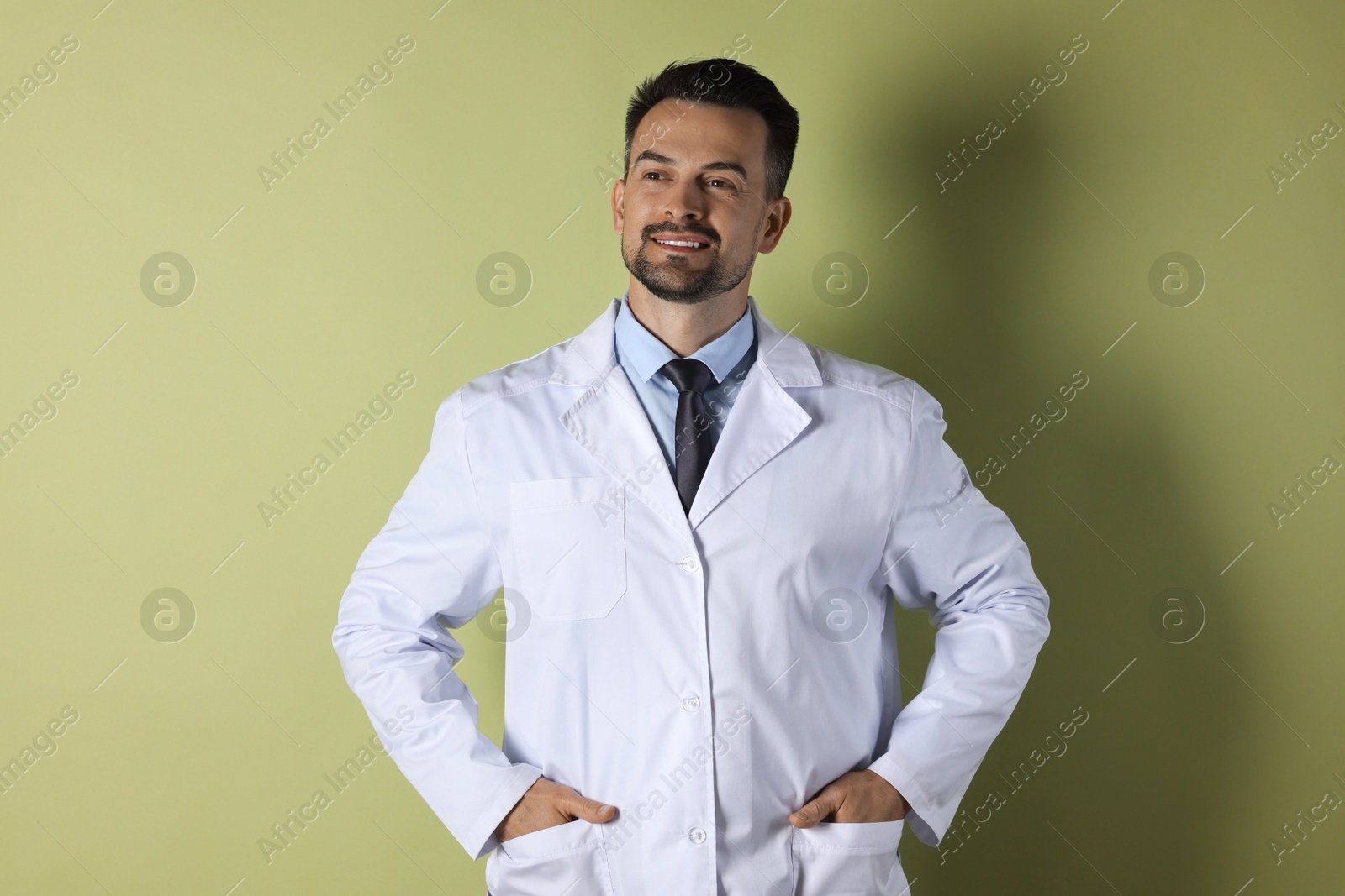 Photo of Portrait of smiling doctor on olive background