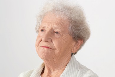 Portrait of senior woman on light grey background, closeup