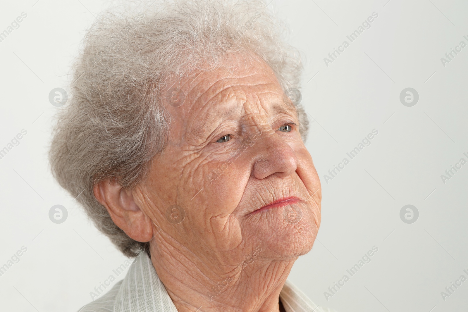 Photo of Portrait of senior woman on light grey background, closeup