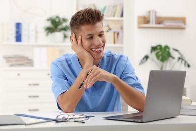 Photo of Medical student in uniform studying at table indoors