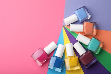 Photo of Set of different nail polishes on color background, flat lay. Space for text