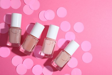 Photo of Set of nude nail polishes in bottles on pink background, flat lay. Space for text