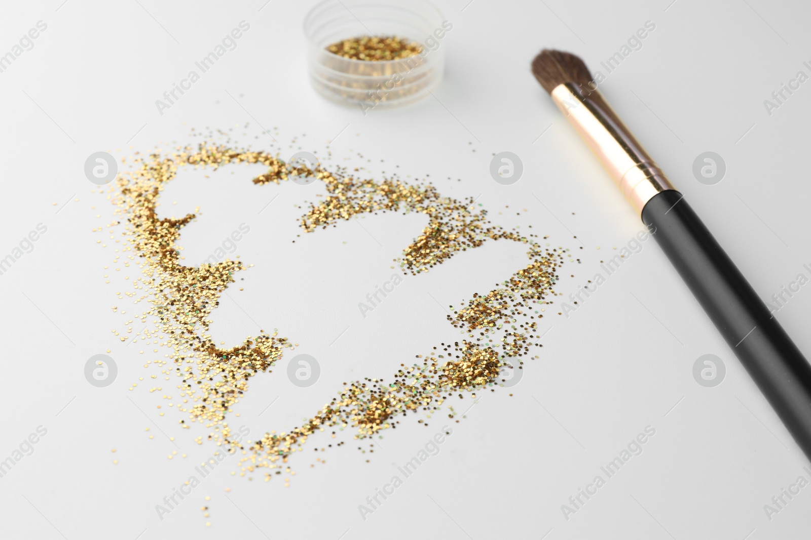 Photo of Christmas tree made of glitter and makeup brush on white background, closeup