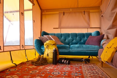 Photo of Comfortable sofa and tourist stuff in glamping site