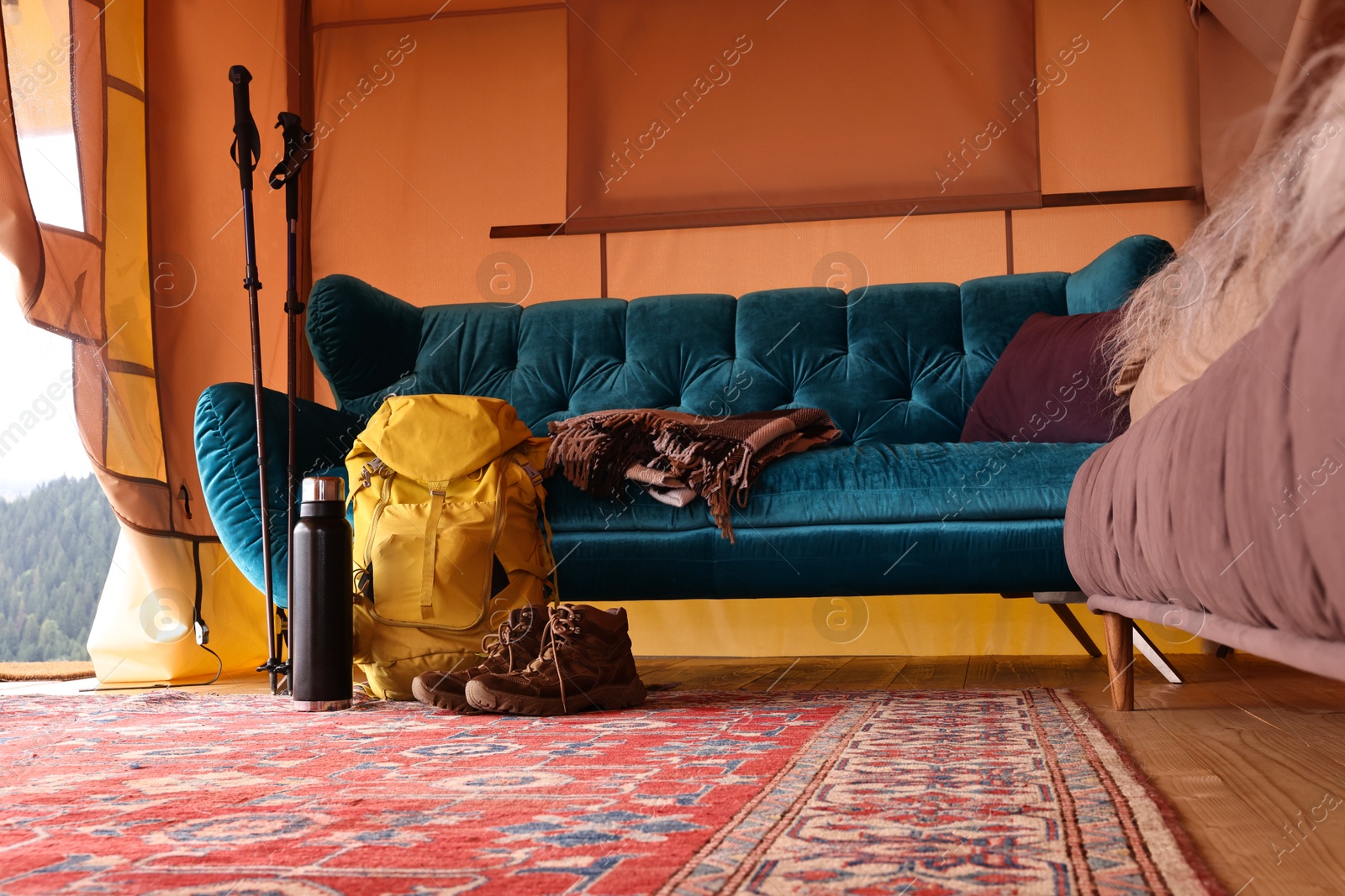 Photo of Comfortable sofa and tourist stuff in glamping site