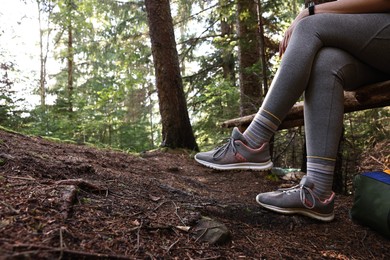 Photo of Young hiker wearing sneakers in forest, closeup