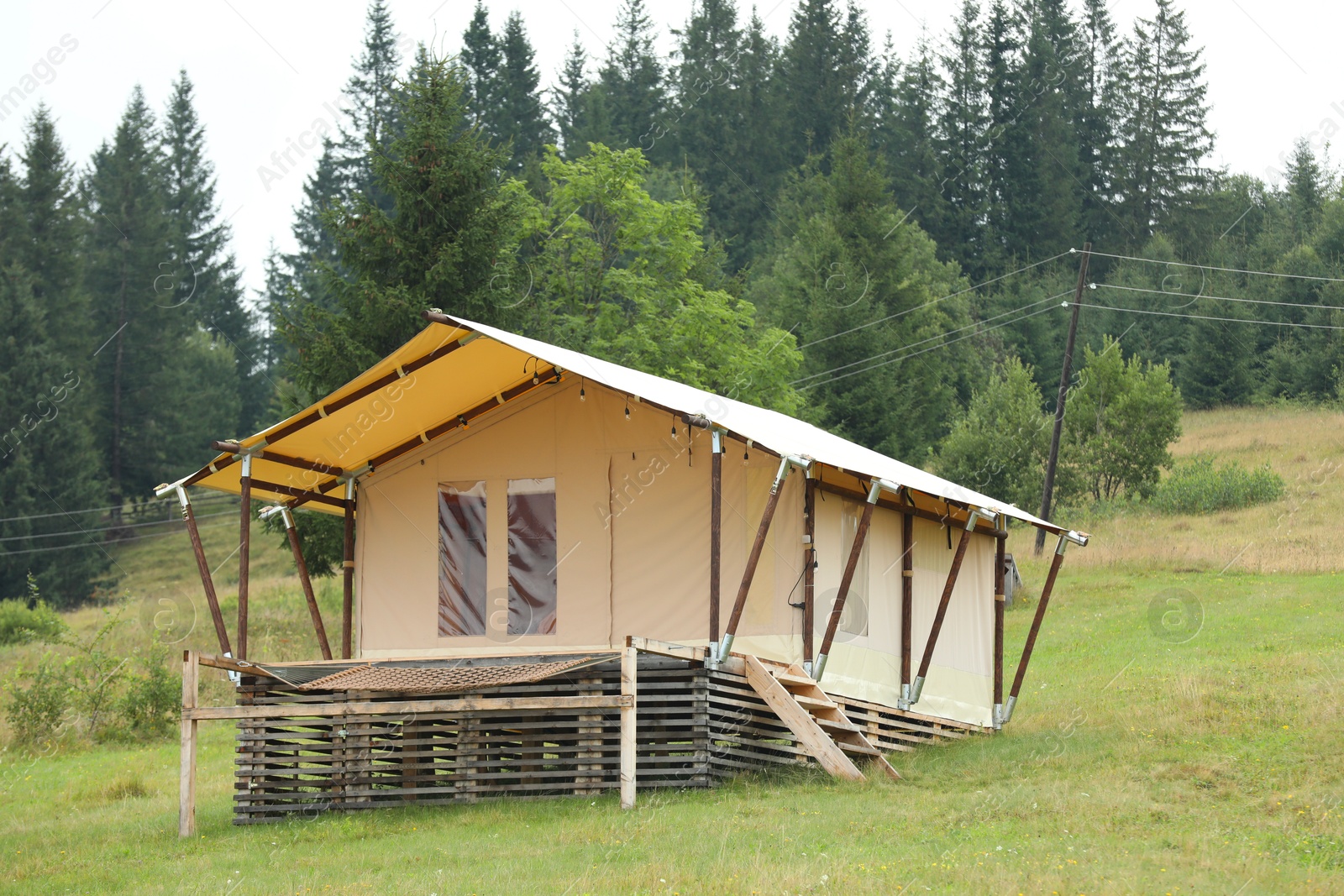 Photo of Tent and green forest in mountains. Glamping site