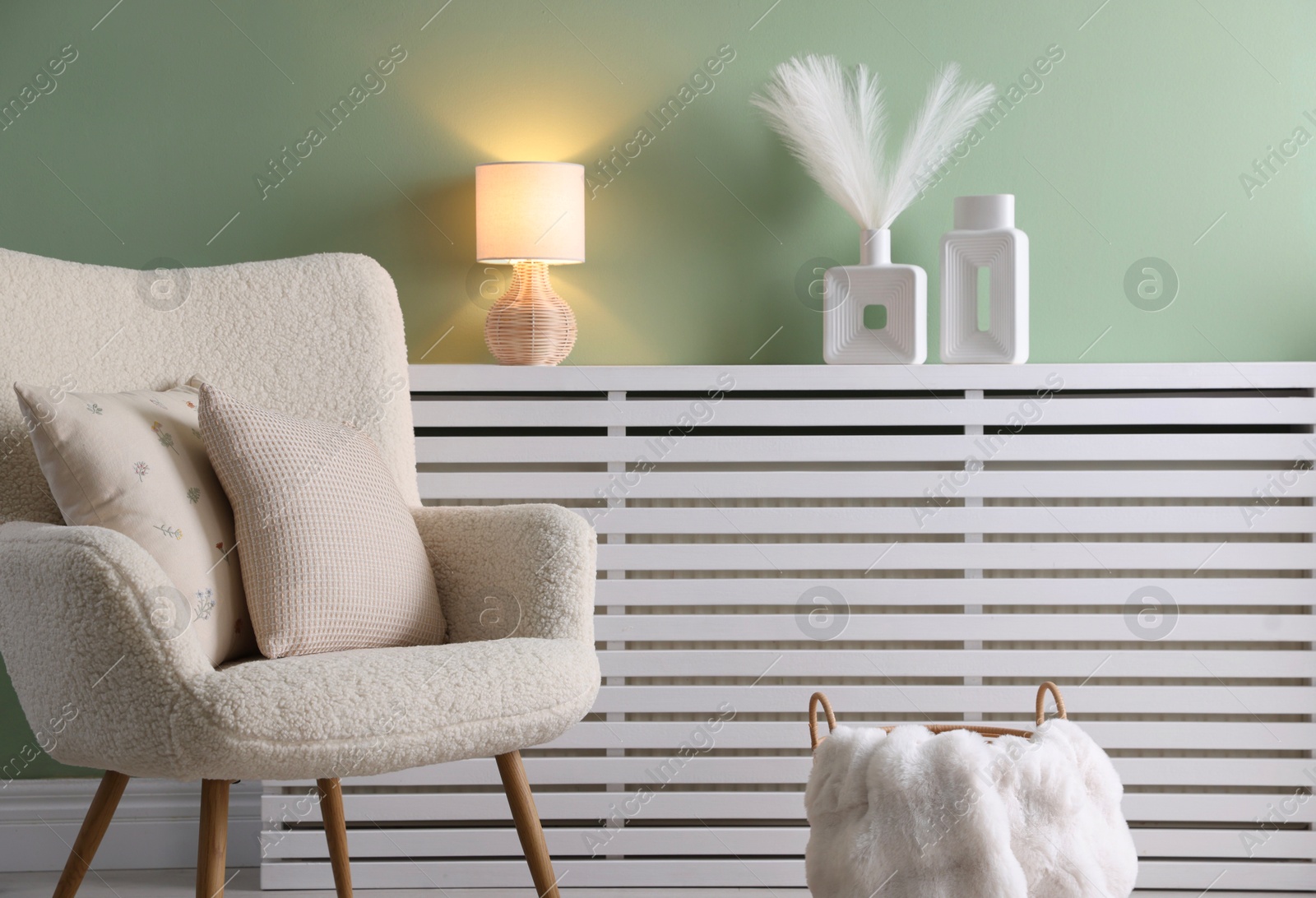 Photo of Two soft pillows on light armchair in living room