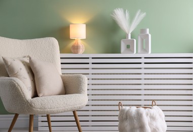 Photo of Two soft pillows on light armchair in living room