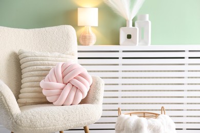 Photo of Decorative pillows on light armchair in living room