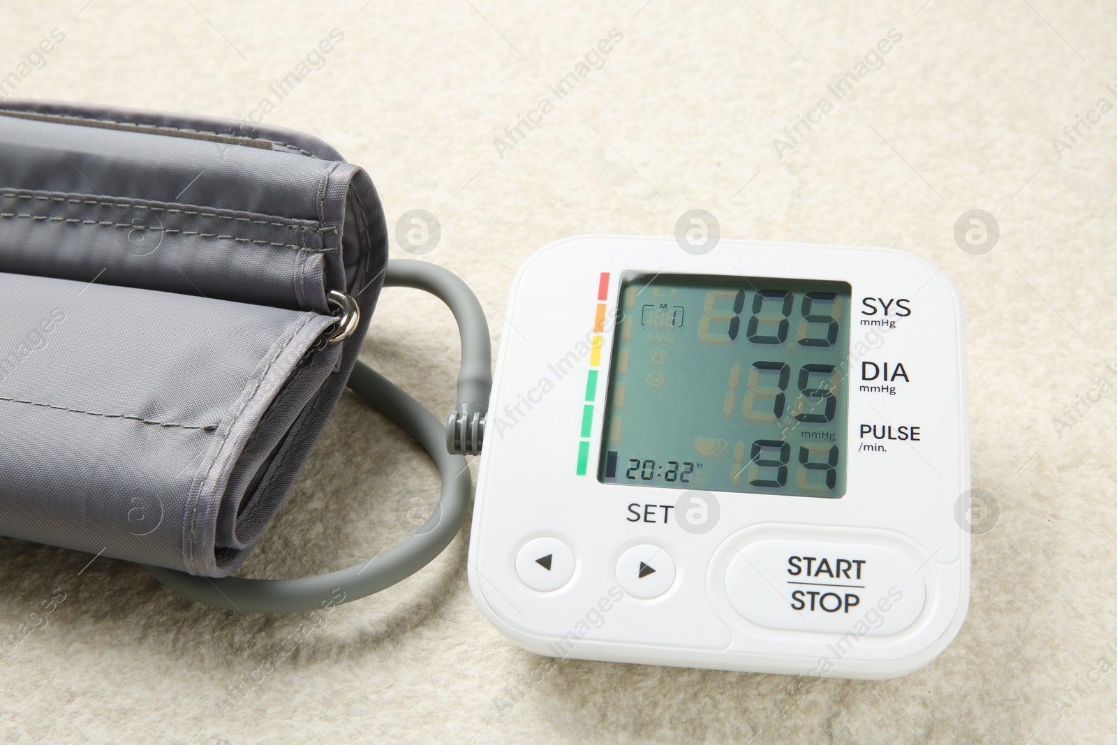 Photo of Blood pressure measuring device on light textured background, closeup