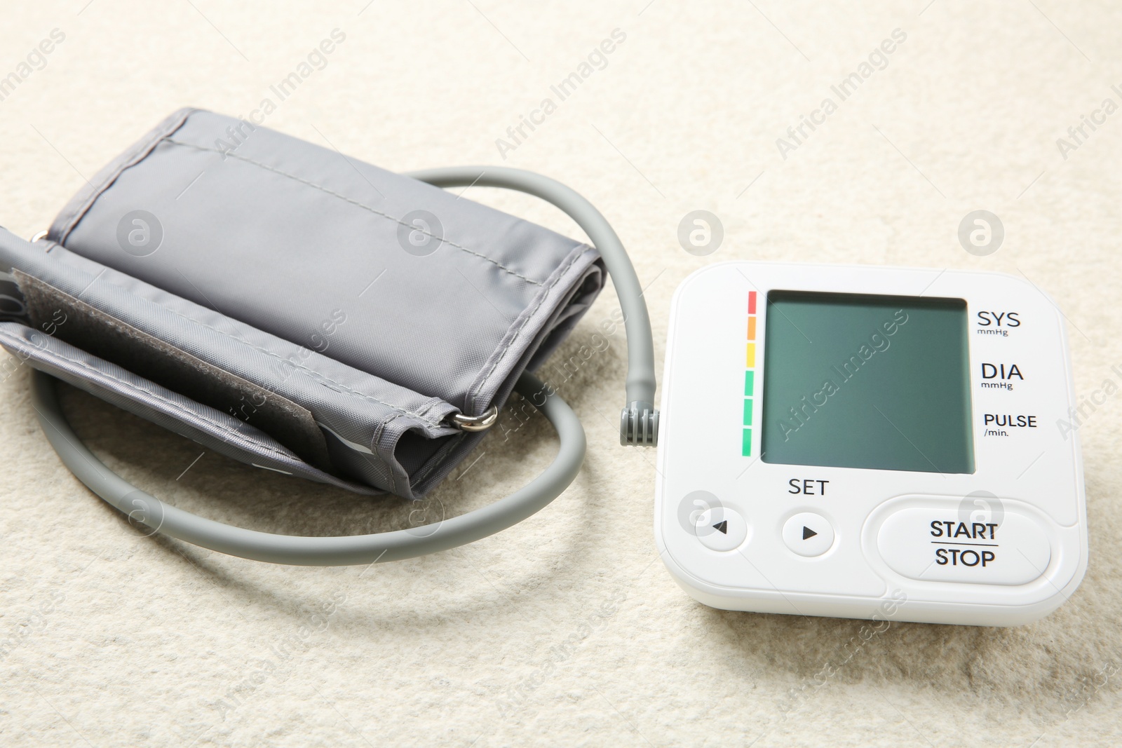 Photo of Blood pressure measuring device on light textured background, closeup