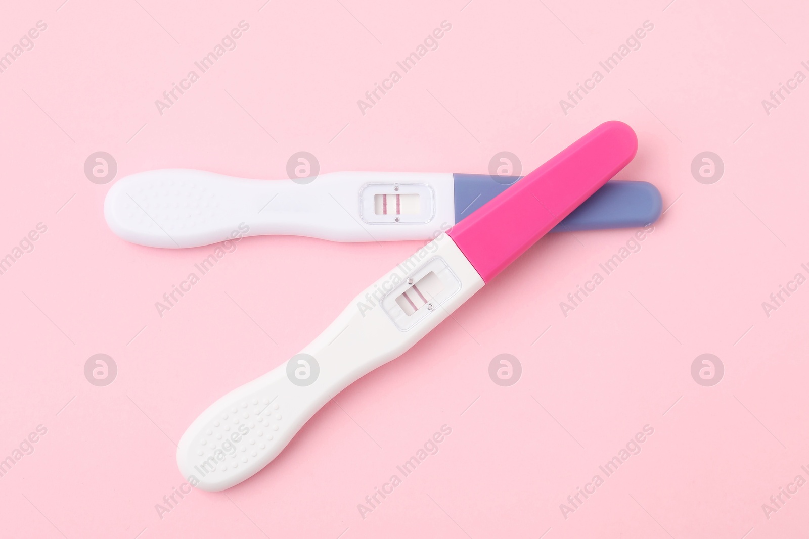 Photo of Pregnancy tests on pink background, top view