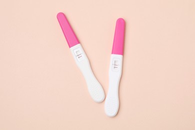 Photo of Pregnancy tests on beige background, top view