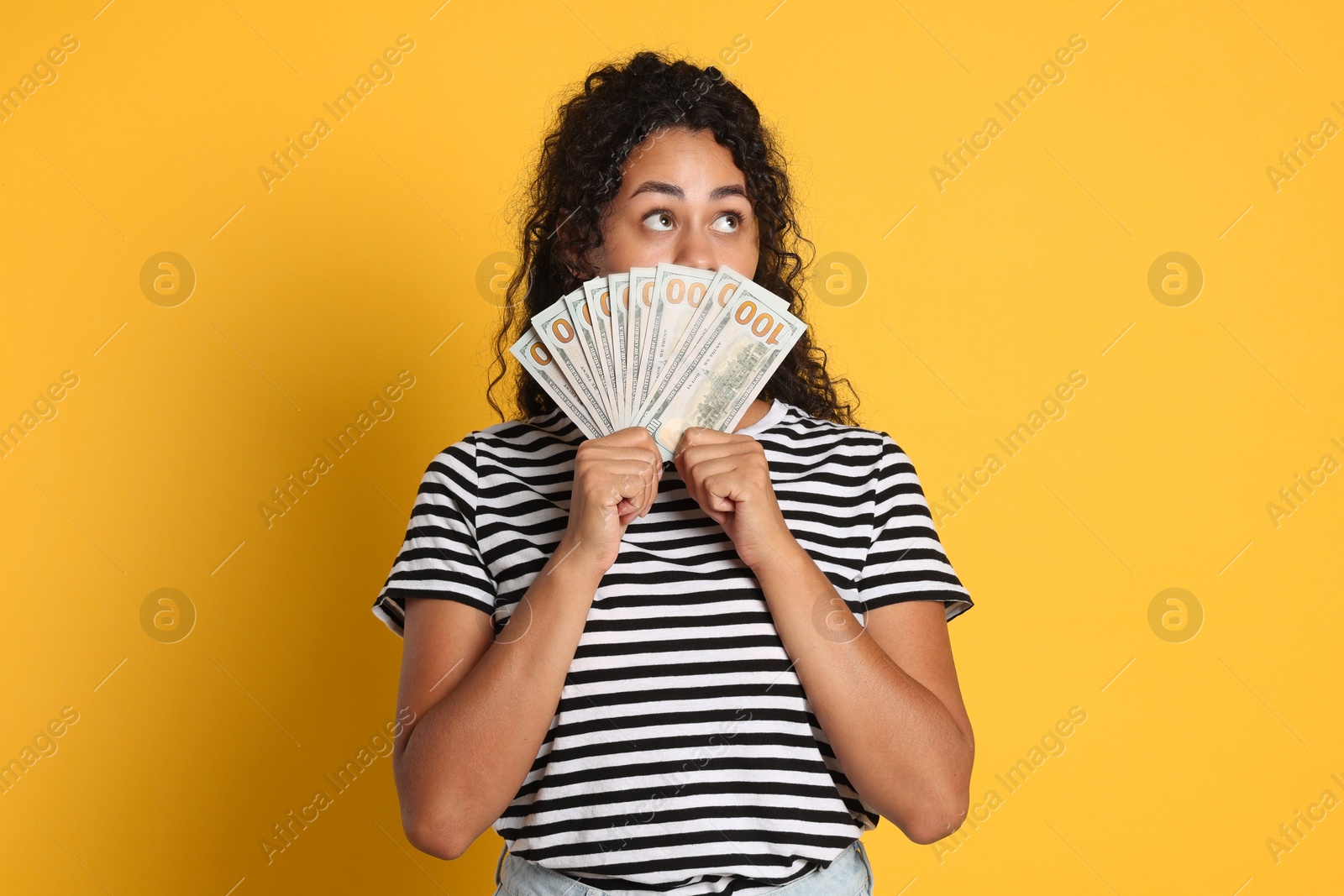 Photo of Woman with dollar banknotes on yellow background