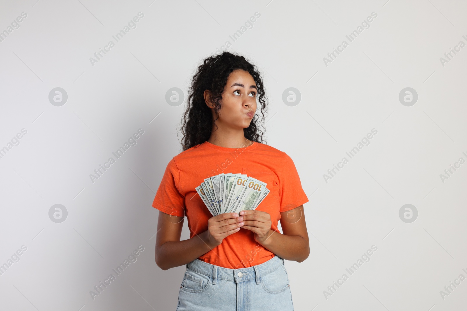 Photo of Woman with dollar banknotes on light grey background