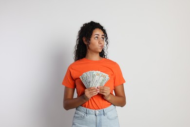 Photo of Woman with dollar banknotes on light grey background