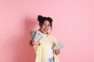 Photo of Happy woman with dollar banknotes on pink background