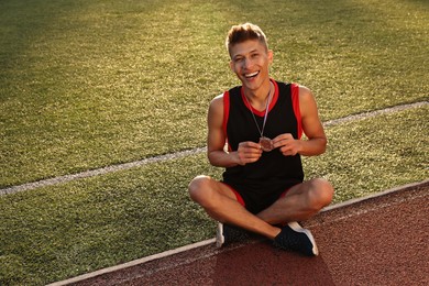 Happy winner with silver medal at stadium. Space for text