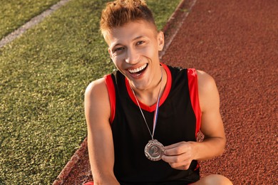 Happy winner with silver medal at stadium