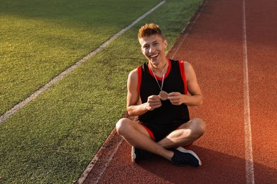 Happy winner with silver medal at stadium. Space for text